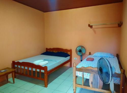 莫约加尔帕Rustic House Hostel的卧室配有两张床,墙上配有风扇