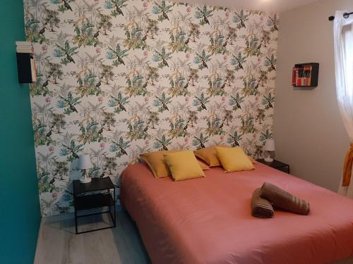 拉波勒Lisière de la Forêt的一间卧室配有一张红色的床和花卉壁纸