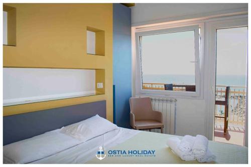 丽都迪奥斯蒂亚Ostia Holiday Sunset的一间卧室设有一张床和一个美景窗户。