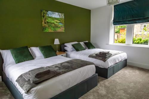 BaildonDetached Luxury 6 beds, Super Wi-fi, easy parking and Hot-tub的配有两张床铺的绿色墙壁和窗户