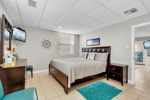 南帕诸岛Bayfront condo with water view & boat slips!的一间卧室配有一张床、一张书桌和一台电视。
