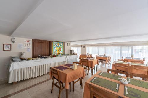 安塔利亚Şehir Hotel的用餐室配有木桌和椅子