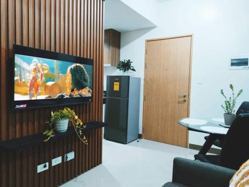 马尼拉2BR SMDC Bloom Residences Near NAIA Wi-fi +Netflix的客厅设有壁挂式平面电视。