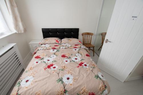 ShirleyOAK AVENUE HOME的一间卧室配有一张带花卉床罩的床