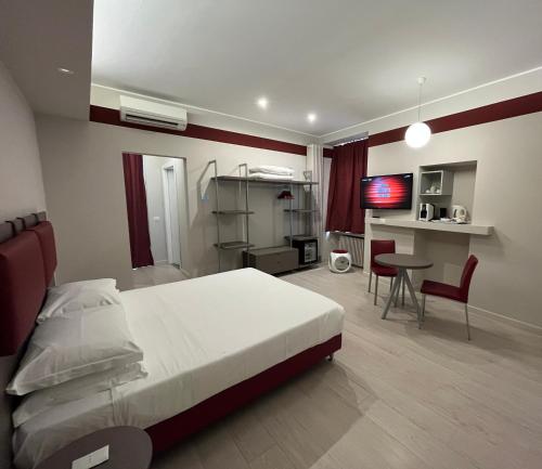 伊夫雷亚Borgo Yporegia的一间卧室配有一张床、一张桌子和一台电视。