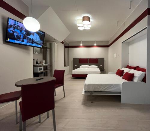伊夫雷亚Borgo Yporegia的一间卧室设有两张床,墙上配有电视。