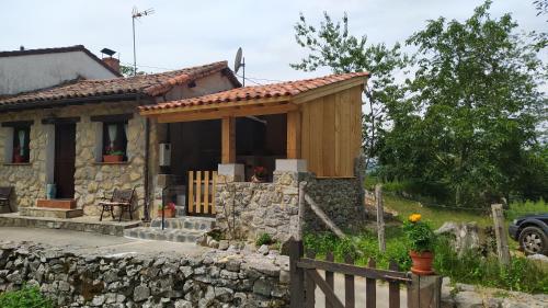 NavaLa Casa de la Vieja的前面有围栏的小石头房子
