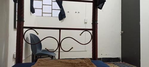 奥里萨巴Hostal Casa Azul, Chantli的一张带木架和蓝色椅子的床