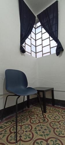 奥里萨巴Hostal Casa Azul, Chantli的窗户房间里一张椅子和一张桌子