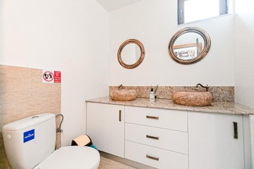 Bughea de SusPensiunea Casa de Vis的浴室设有卫生间,墙上设有两面镜子。
