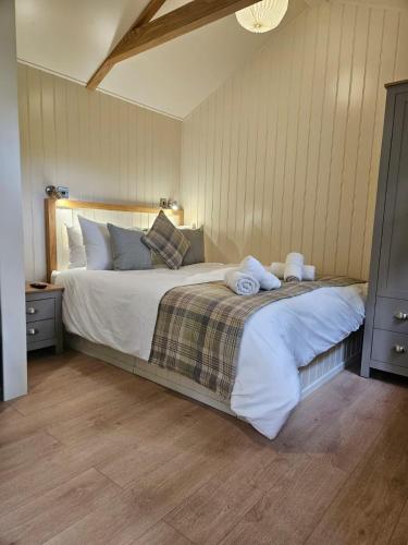 卡纳芬Woodland Shephards Hut - 'Aristocrat'的一间卧室配有一张大床和毛巾