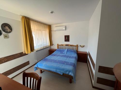 里拉Centaur Family Hotel的一间卧室配有一张带蓝色棉被的床