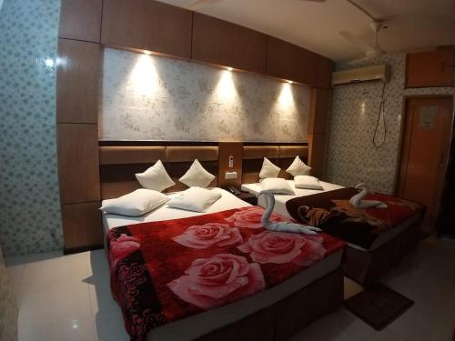 库克斯巴扎Saint Martin Resort的两张床铺,位于酒店房间,上面有玫瑰花