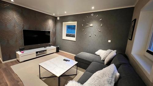 卢恩斯基尔Holiday Home Ljungskile的客厅配有沙发和墙上的时钟