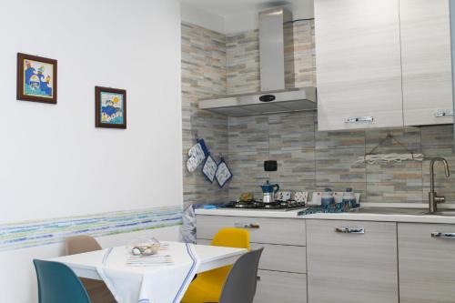 萨莱诺GATTI e MARE的厨房配有桌椅和水槽