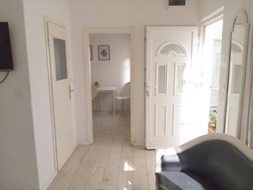 杜布罗夫尼克埃美公寓的走廊上设有白色门和桌子