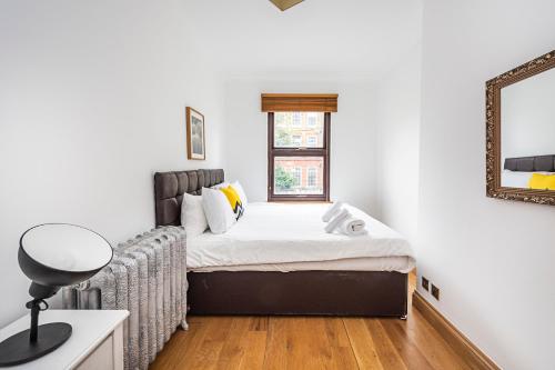 伦敦2 Bedroom Apartment by AV Stays Short Lets Southwark London With Free WiFi的一间小卧室,配有一张床和镜子