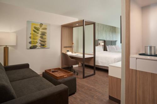 奥兰多SpringHill Suites by Marriott Orlando Lake Nona的酒店客房设有一张沙发和一张床