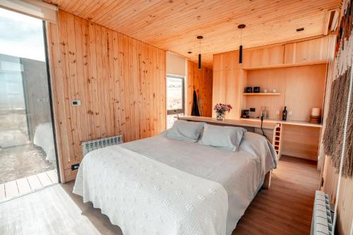 图蓬加托火山Hotel De Cielo的卧室配有一张床铺,位于带木墙的房间内