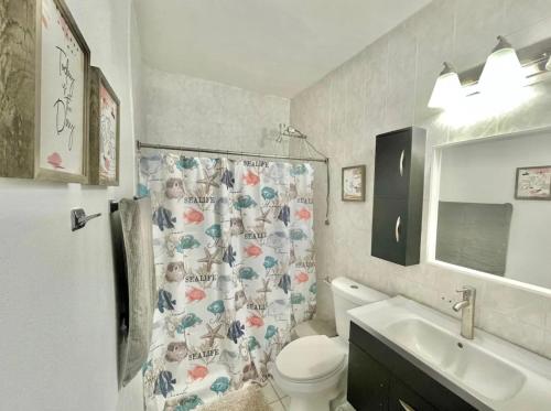 圣胡安Oasis Inn的浴室设有卫生间、水槽和淋浴帘