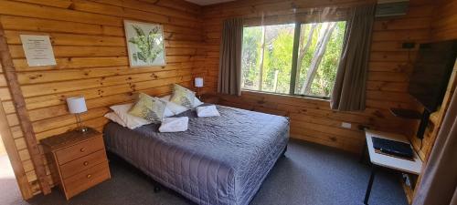 汉默温泉森林山峰汽车旅馆的小木屋内一间卧室,配有一张床