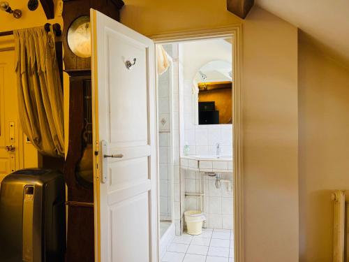 图尔LE JARDIN DU VENDOME的浴室设有白色门和水槽