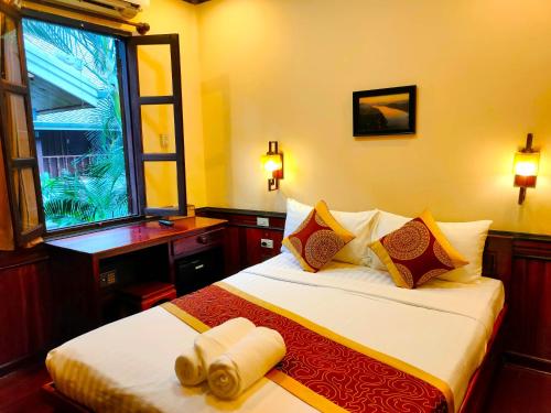 琅勃拉邦Lotus Corner - Vegan & Plant Based B&B的酒店客房设有一张带窗户的床。