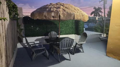 圣胡安Home San Juan的庭院配有桌椅和草伞。