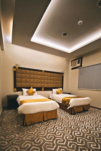 Sīdī Ḩamzahفندق اضواء المدينة的酒店客房设有两张床和投影屏幕