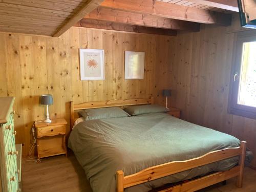 安达洛CHALET JOEN ski & bike Andalo的一间卧室设有一张床和木墙