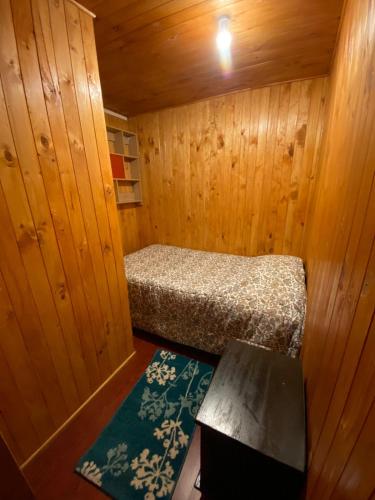 圣地亚哥Hospedaje Pudahuel的小木屋内的小房间,配有一张床