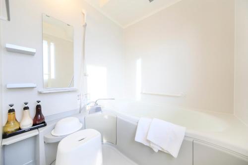 富士河口湖富士温泉寺梦殿日式旅馆的白色的浴室设有水槽和卫生间。