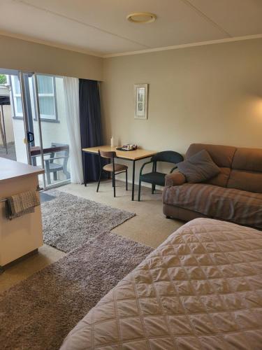 莱文Totara Lodge Motel的客厅配有沙发和桌子