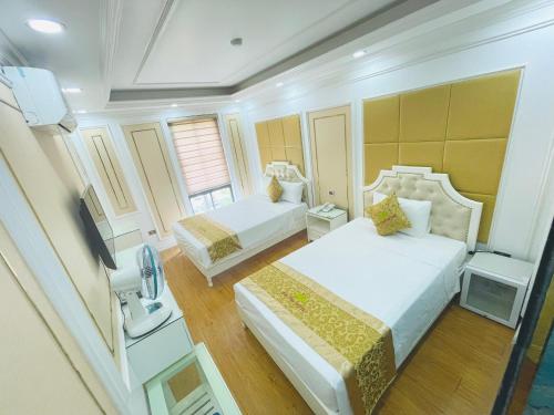 下龙湾Bài Thơ Mountain Hotel的酒店客房设有两张床和电视。