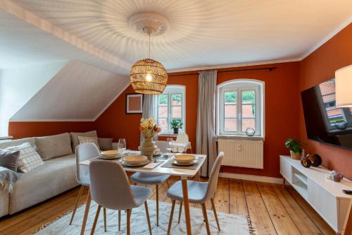 柯尼希施泰因易北Moderne Ferienwohnung mit Festungsblick im Zentrum的客厅设有橙色墙壁和桌椅