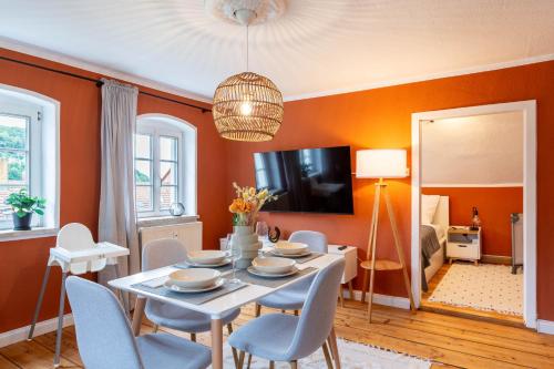 柯尼希施泰因易北Moderne Ferienwohnung mit Festungsblick im Zentrum的一间拥有橙色墙壁和桌椅的用餐室