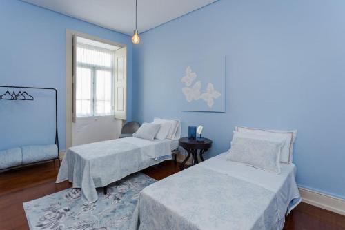 孔迪镇708 Mugnano House Aveleda的蓝色的客房配有两张床和一张桌子