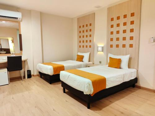 古晋Hotel 98的酒店客房设有两张床和电视。