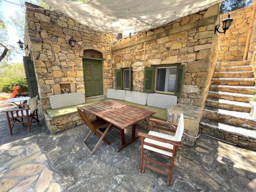 LakkíonPetrino 2 - Traditional Lerian House的庭院设有木桌、椅子和石墙