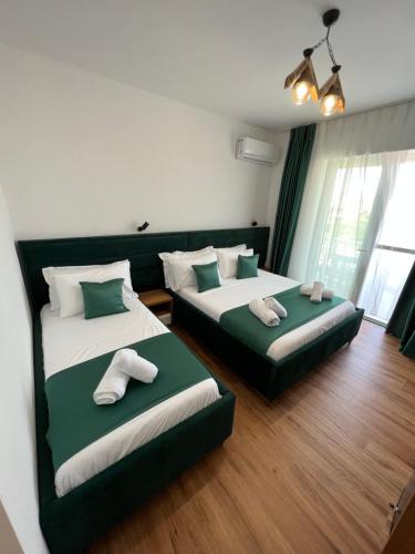卡萨米尔ILLYRIAN hotel的绿白色客房内的两张床