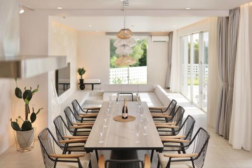 宫古岛Crystal Villa Bayside的一间带长桌和椅子的用餐室