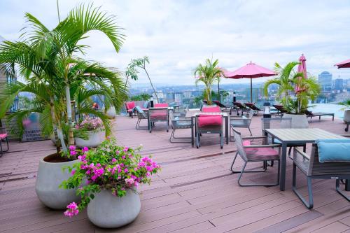 内罗毕Exquisite 2BD at Skynest Residences with rooftop heated pool的庭院设有桌椅,棕榈树和鲜花