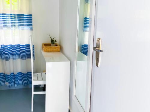 韦利格默海湾屋旅馆的浴室设有白色和蓝色的淋浴帘。