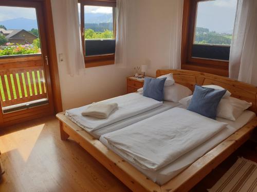 拉姆绍达赫斯坦Bergführerhaus的一间卧室配有带白色床单和蓝色枕头的木制床