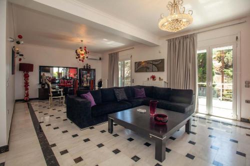 纳夫普利翁Unique, elegant Bourtzi View Villa的客厅配有黑色沙发和桌子