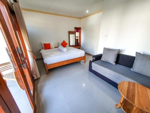 金塔马尼Batur Happy House的客房设有床、沙发和桌子。