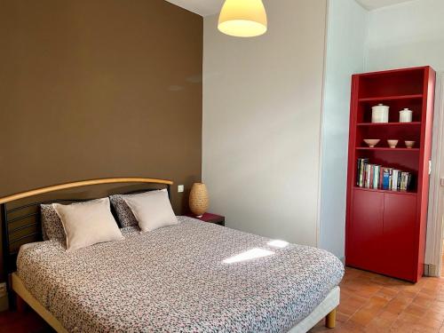 沙布利Chez Bea的一间卧室设有一张床和一个红色书架