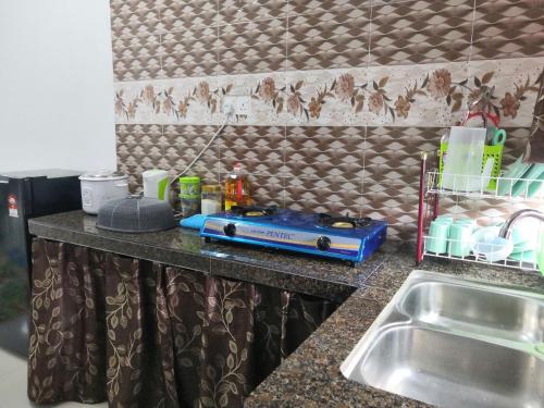 PendangMira Homestay Gurun - Pendang的厨房柜台设有水槽和餐具。