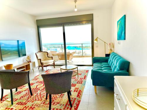 纳哈里亚Vacation Apartment by The Sea - Achziv的客厅配有蓝色的沙发和椅子