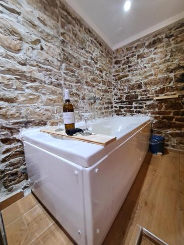 吉诺卡斯特"Villa 70" Guesthouse的浴缸顶部的一瓶葡萄酒